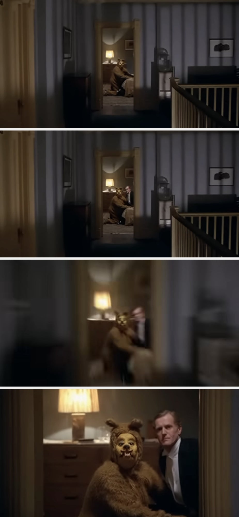 A creepy scene from a movie shows a person in a bear costume kneeling in front of another person, capturing an eerie hallway moment
