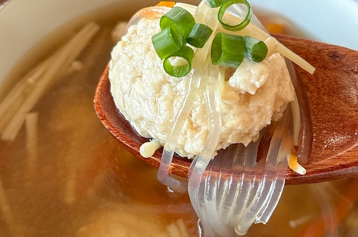 鶏団子が乗ったスプーン。スープの中にえのきとにんじんが入っている。