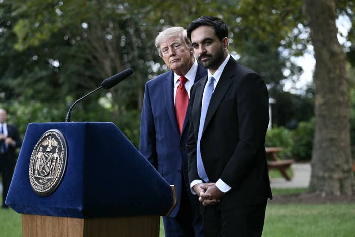 I don’t know who these people are, but one is speaking at a podium outdoors, both in formal suits