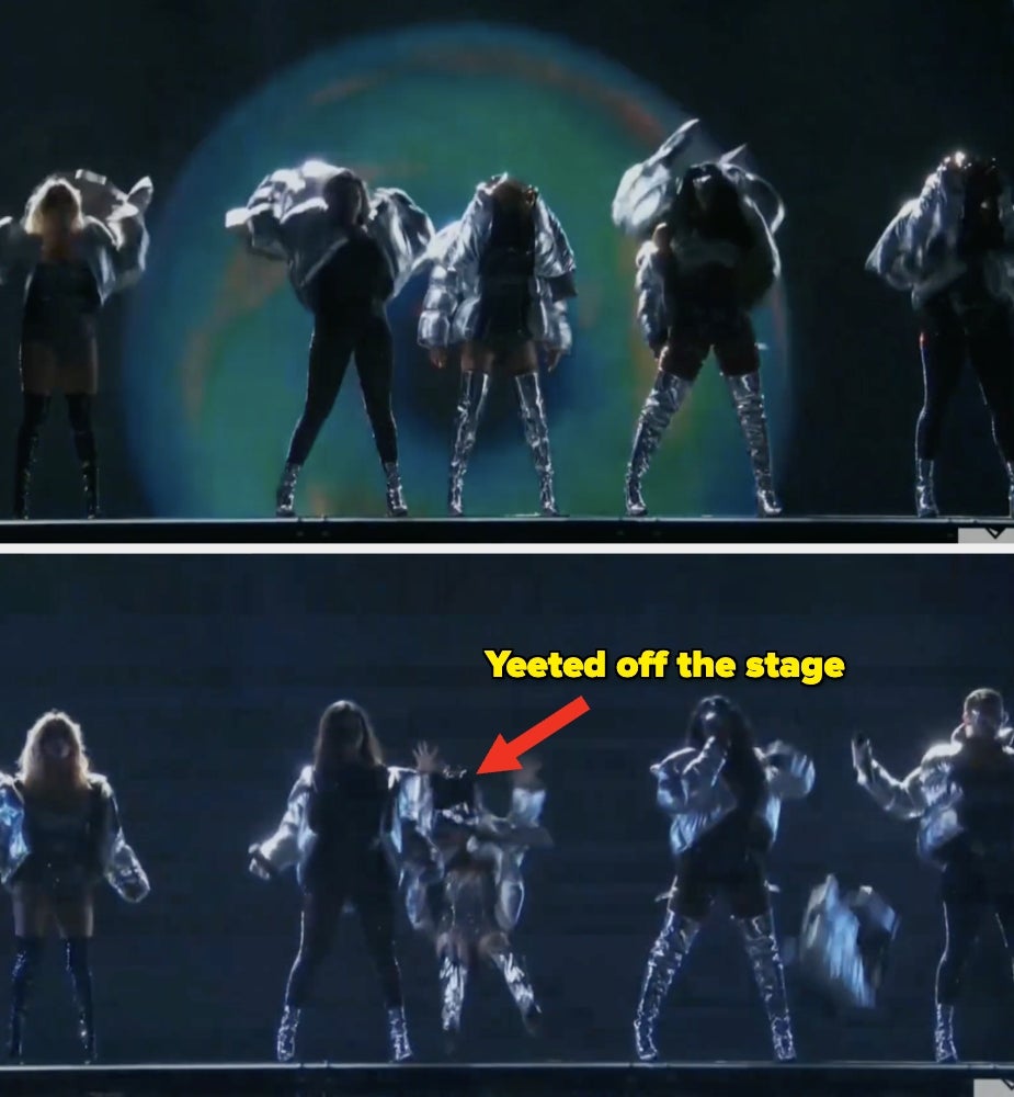 Five performers on stage; one is humorously falling or being pushed, adding a playful element to the performance