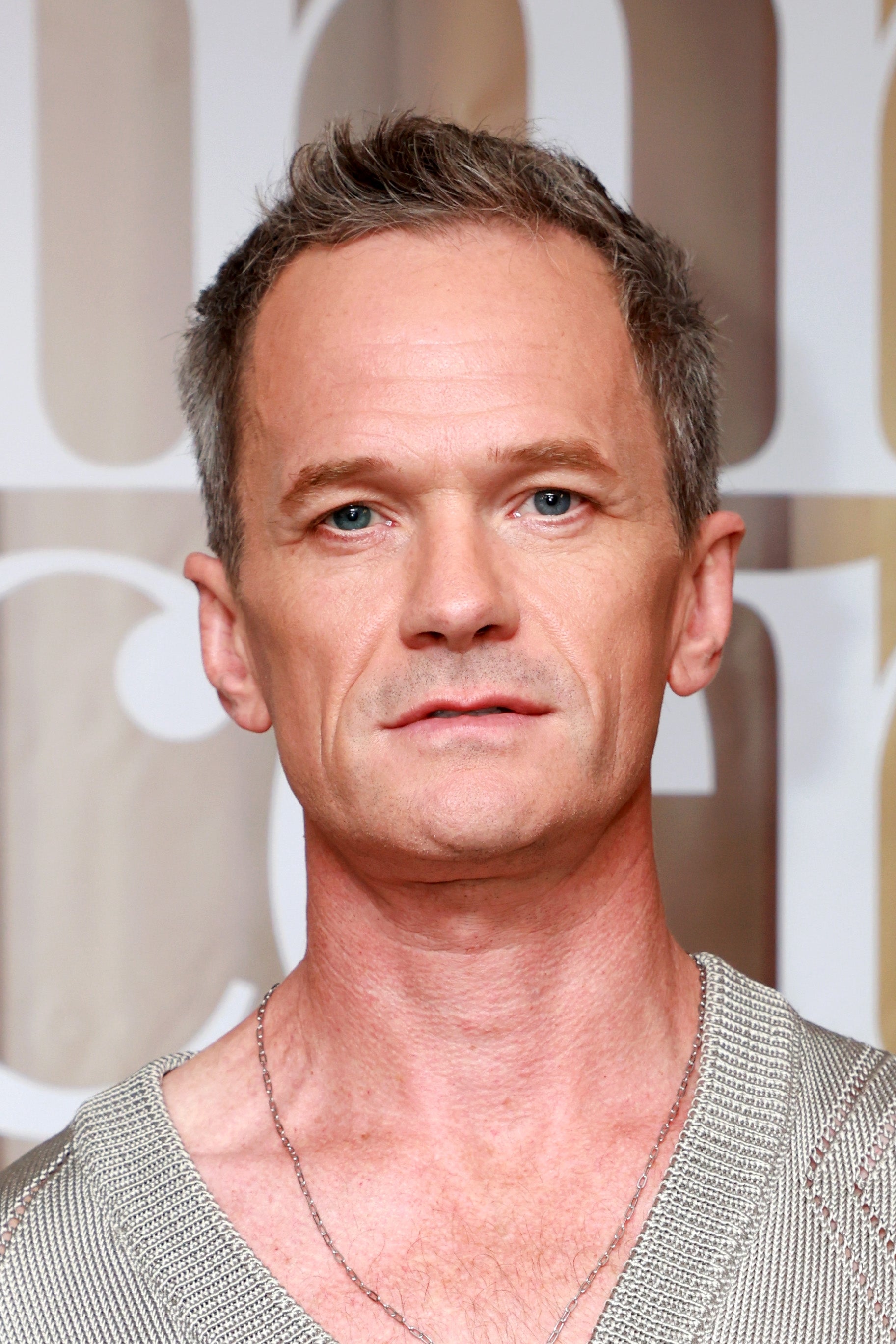 A person wearing a textured shirt on a red carpet at a celebrity event