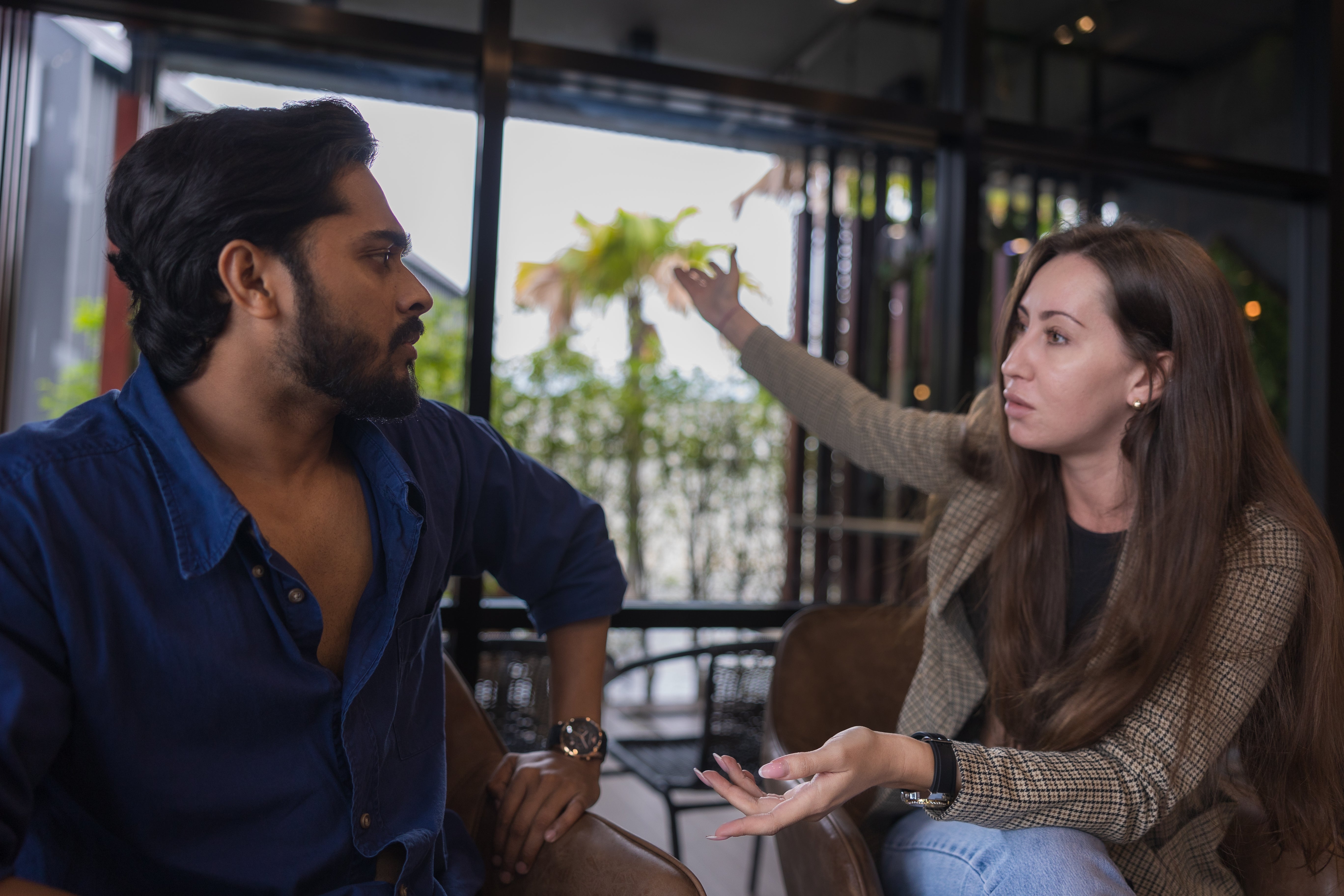 Two people having a serious discussion indoors, with one gesturing while speaking. This could imply a debate or explanation about a health topic