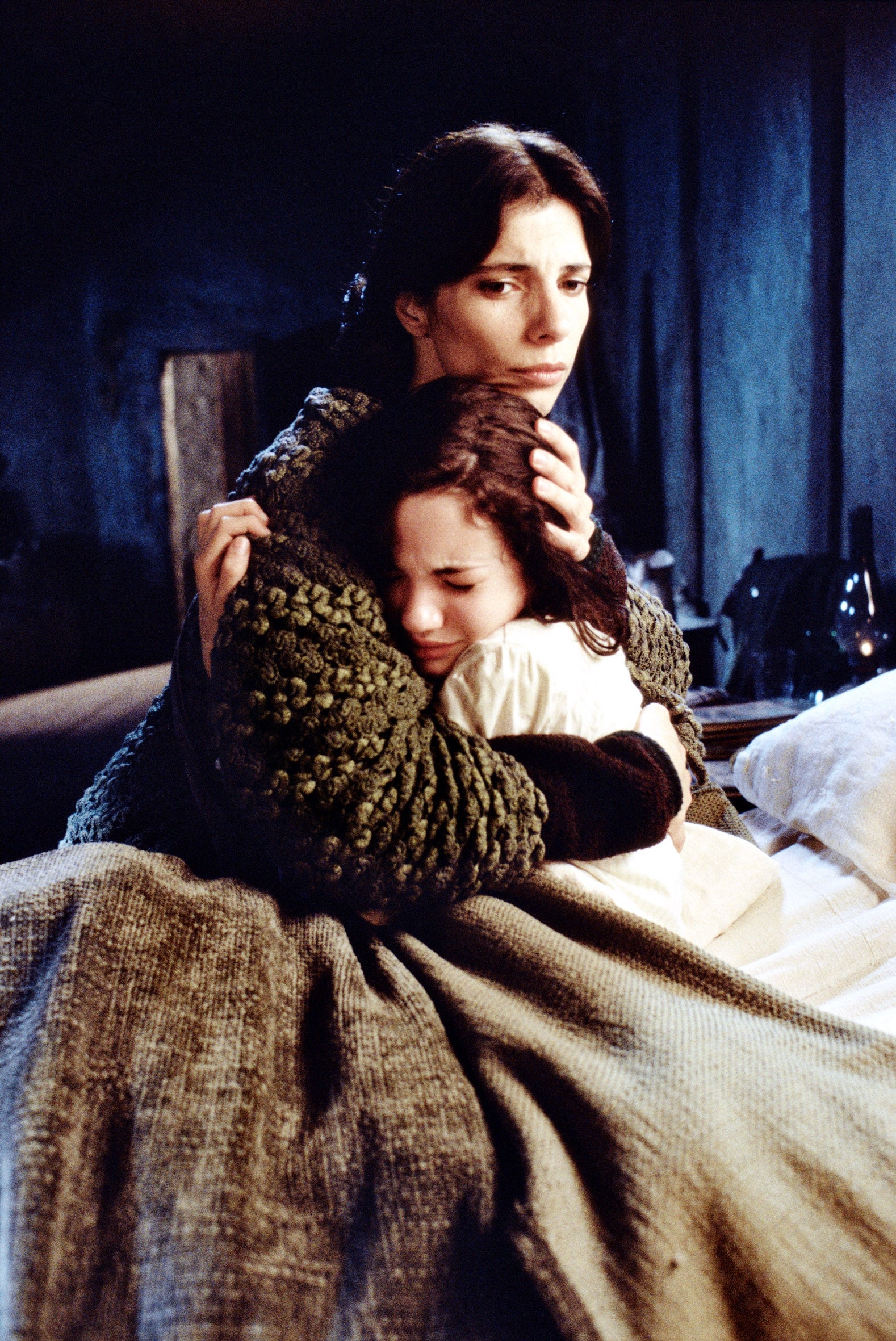 A pistillate   successful  textured covering  embraces a kid  connected  a bed, conveying a consciousness   of extortion  and comfort