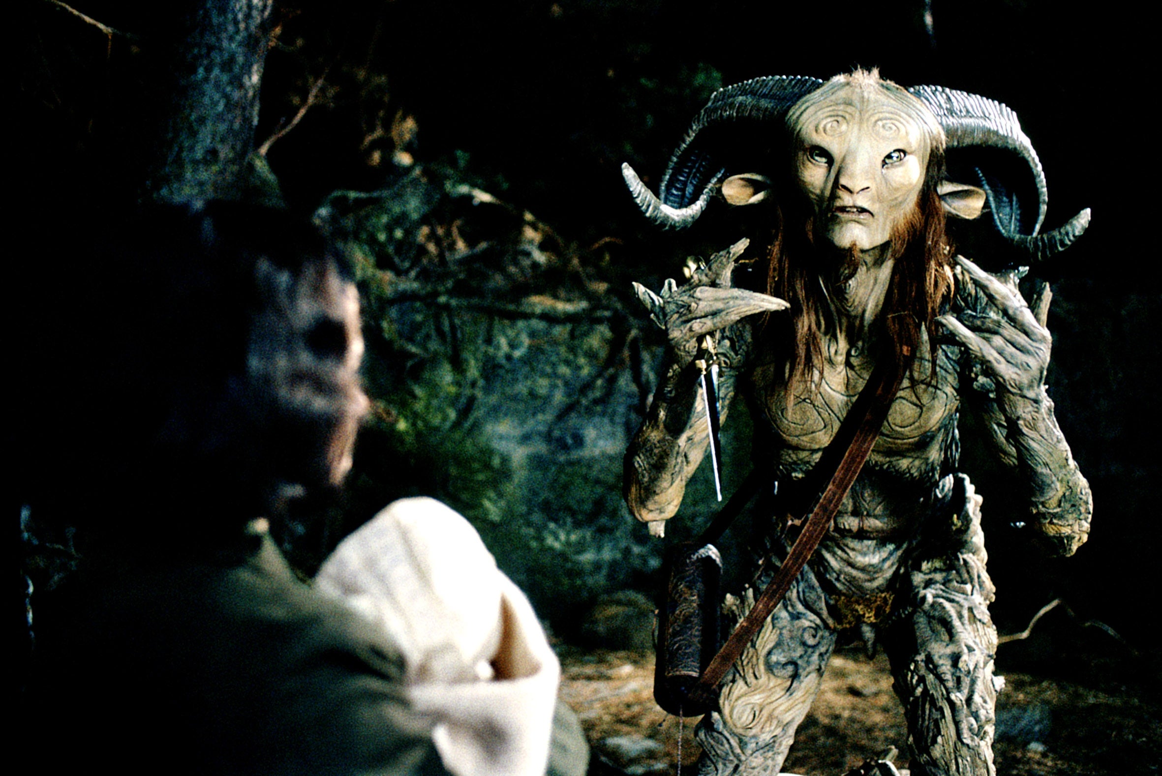A mythical carnal   with horns and intricate patterns faces a idiosyncratic   holding a book, apt  from a phantasy  movie  scene