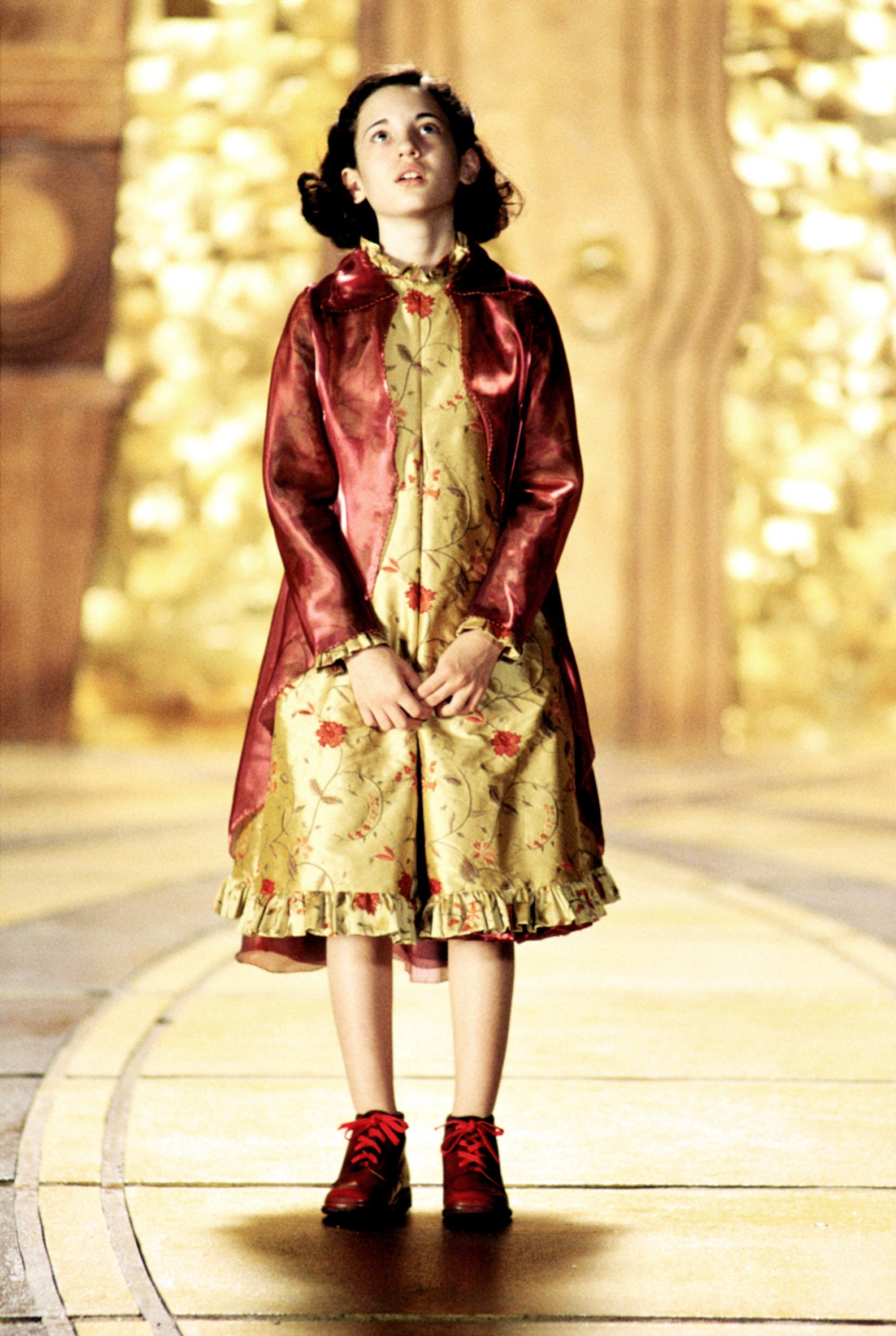 Child histrion  successful  a phantasy  formal  with floral patterns and reddish  coat, lasting  connected  an ornate set, looking upwards