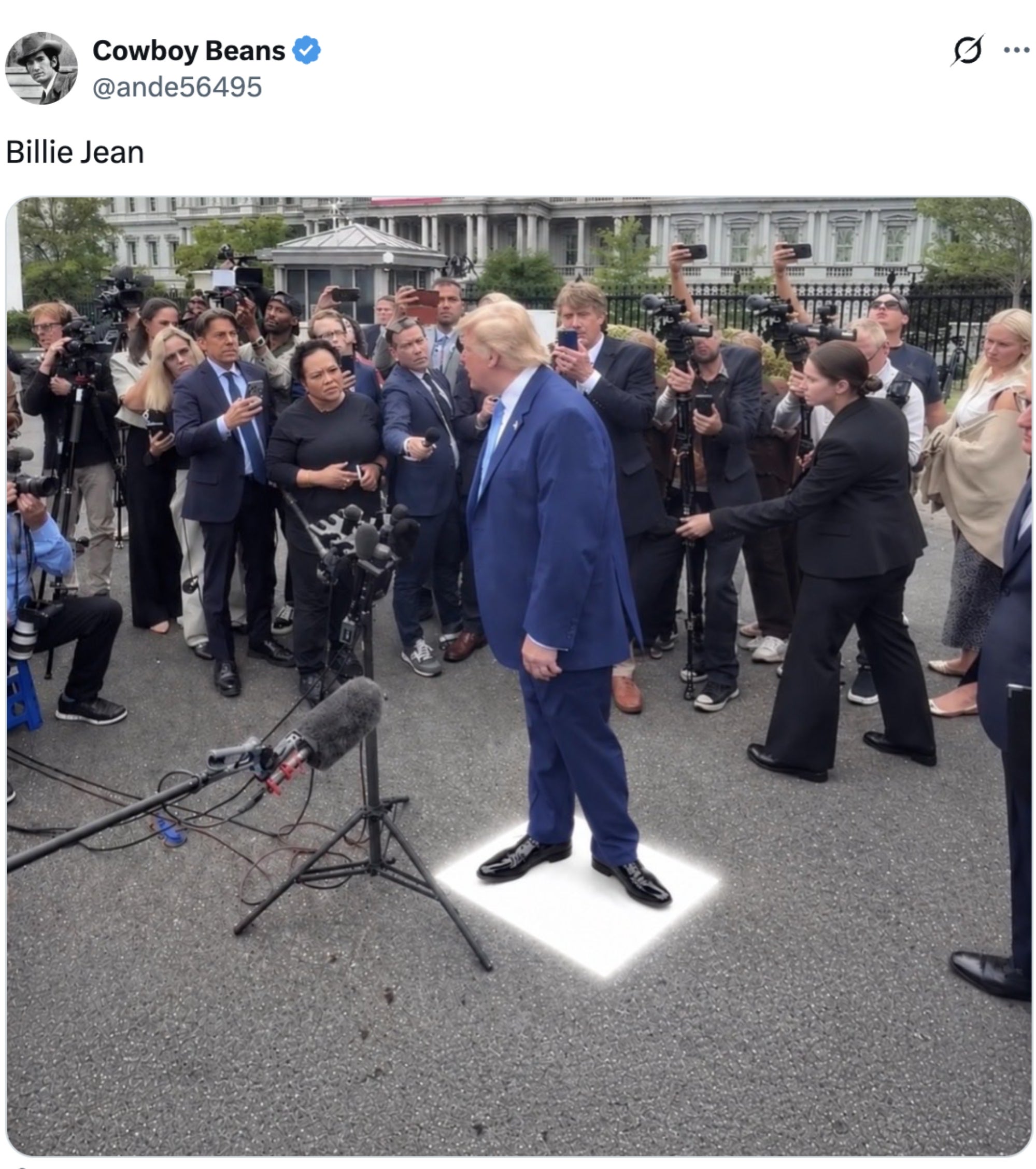 En person i dress står på en hvit firkant, omgitt av journalister og kameraer som fanger scenen