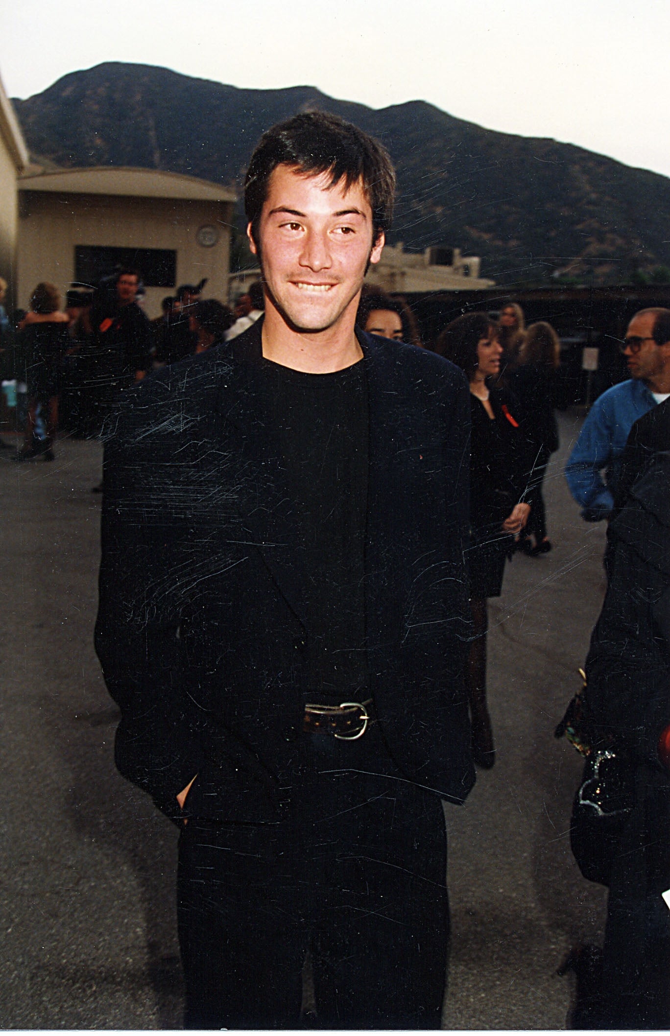 Person in smart casual attire with mountains in the background at an outdoor event