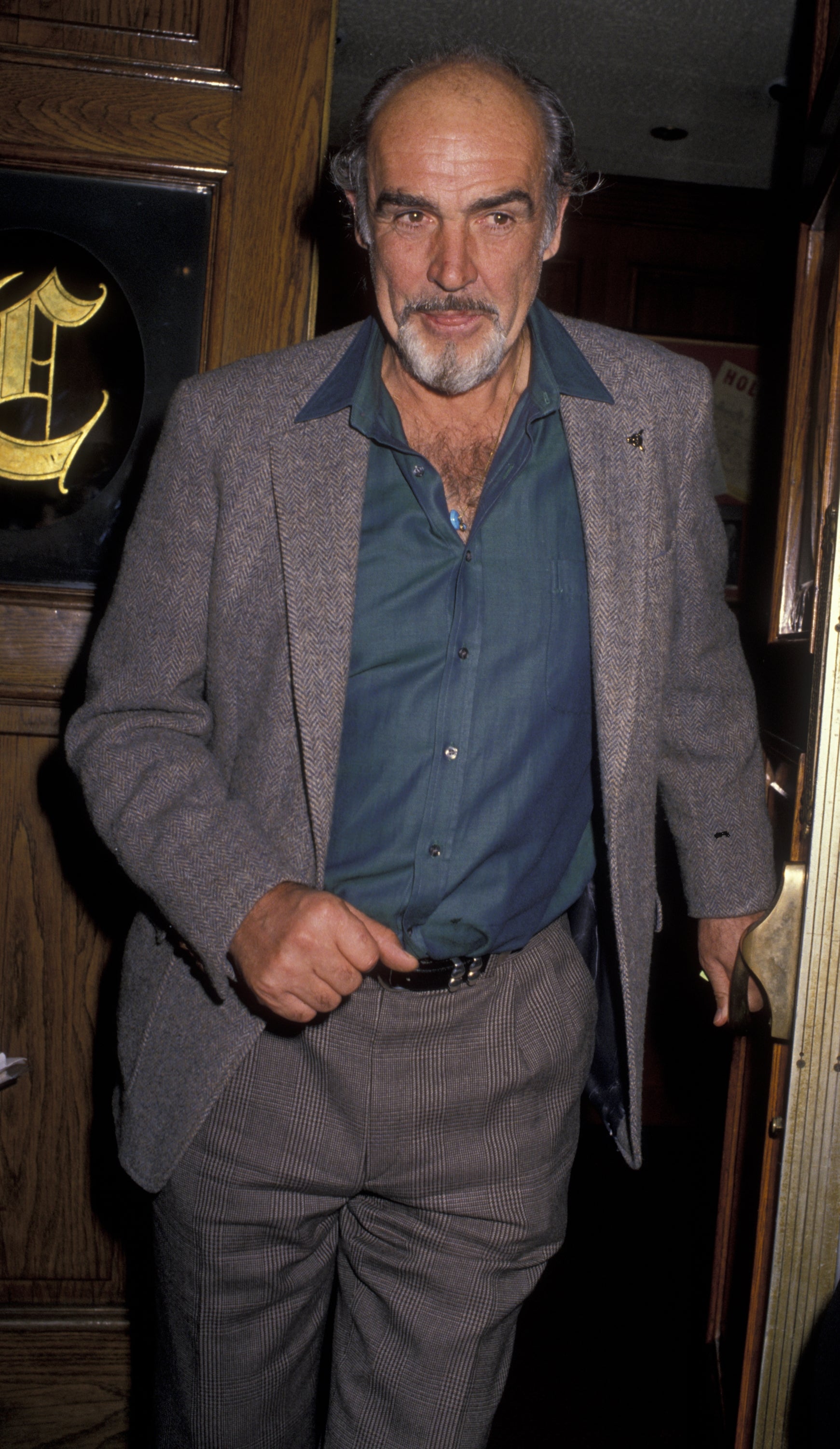 Person in a smart-casual outfit with a blazer and open-collared shirt