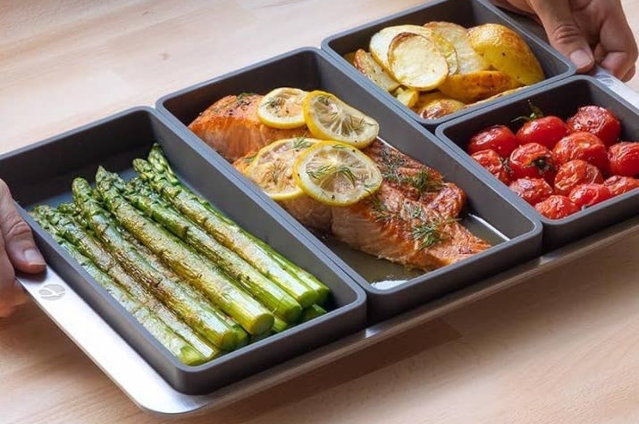 Cookware set with asparagus, salmon with lemon, roasted potatoes, and cherry tomatoes, perfect for organizing and serving meals