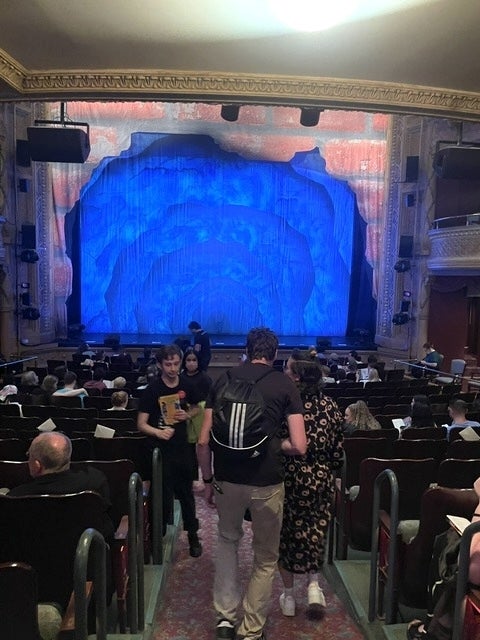 Audience waits successful a theatre arsenic the signifier curtain is illuminated, suggesting an upcoming amusement oregon performance