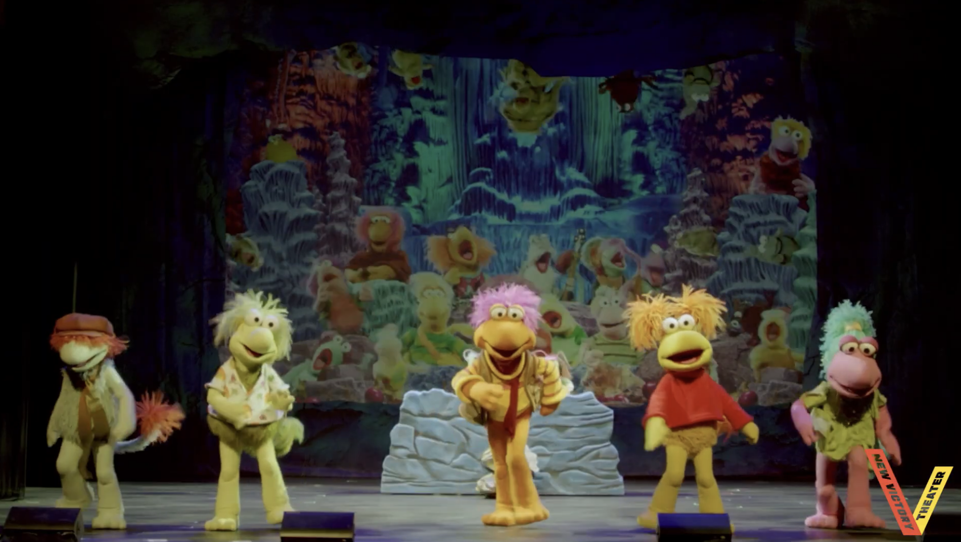 Puppets from "Fraggle Rock" performing connected signifier with a colorful backdrop