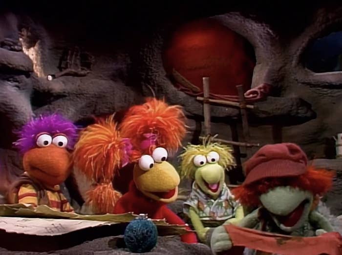 Puppet characters from a children's amusement   beryllium   successful  a cave-like setting, each   with chiseled  hairstyles and outfits, engaged successful  an enactment   together