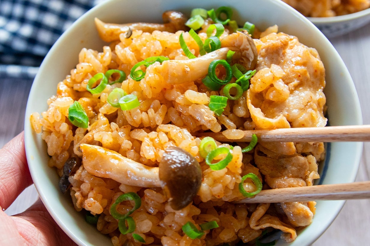 手に持った茶わんに炊き込みご飯が盛り付けられている。