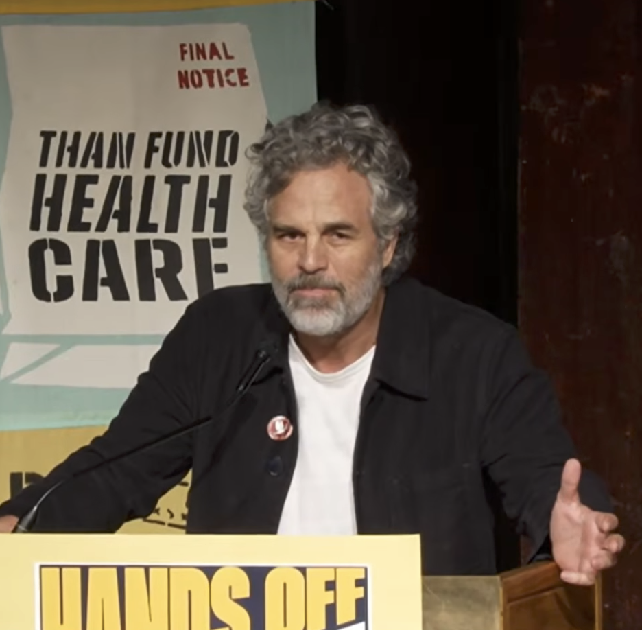Mark Ruffalo speaking at a podium with