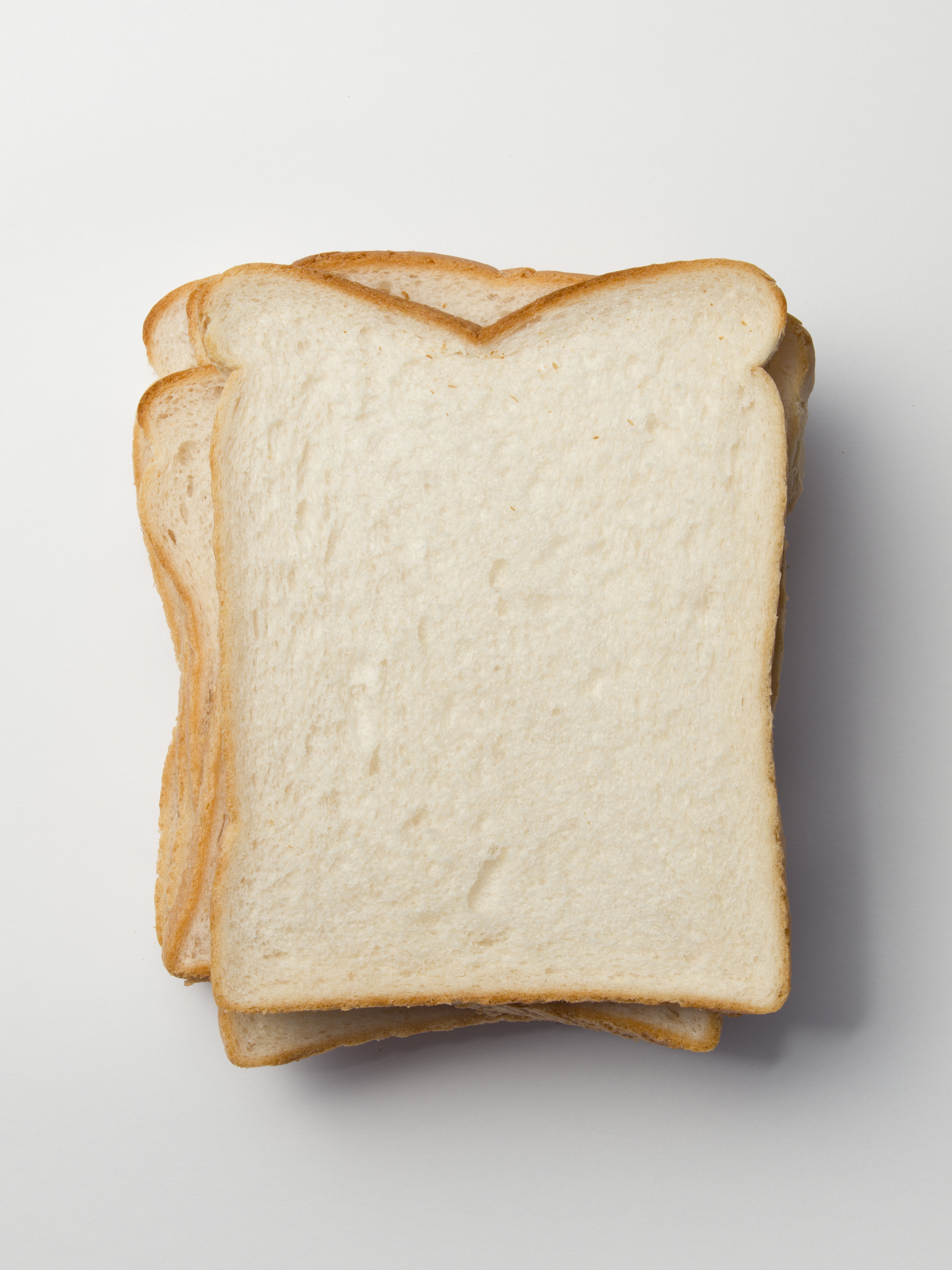 Slices of plain white bread stacked on a flat surface, showcasing simple everyday food, possibly related to budget-friendly topics