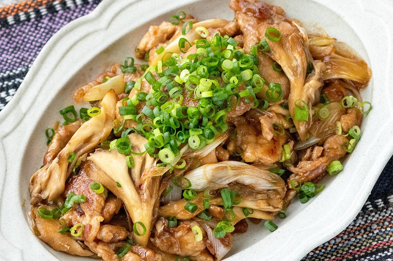 お皿に盛られた舞茸と肉の炒め物。上には刻みネギがトッピングされています。