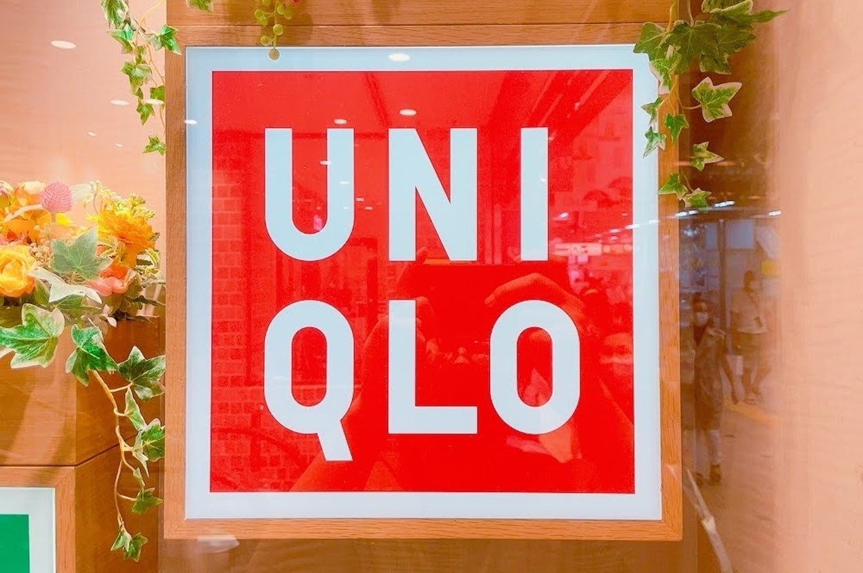 ユニクロの看板が店先に飾られている様子。周囲に緑や花の装飾がある。