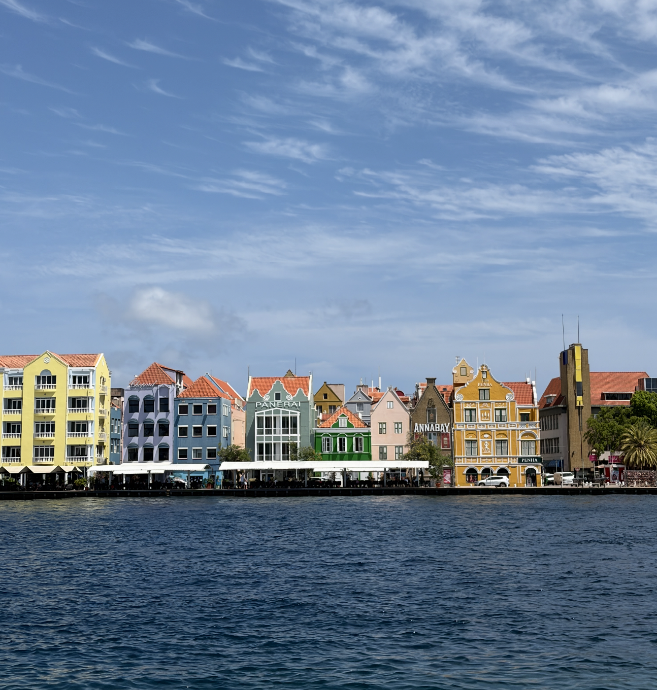 Scenic presumption of colorful waterfront buildings with distinctive European architectural benignant nether a partially cloudy sky, alongside a calm assemblage of water