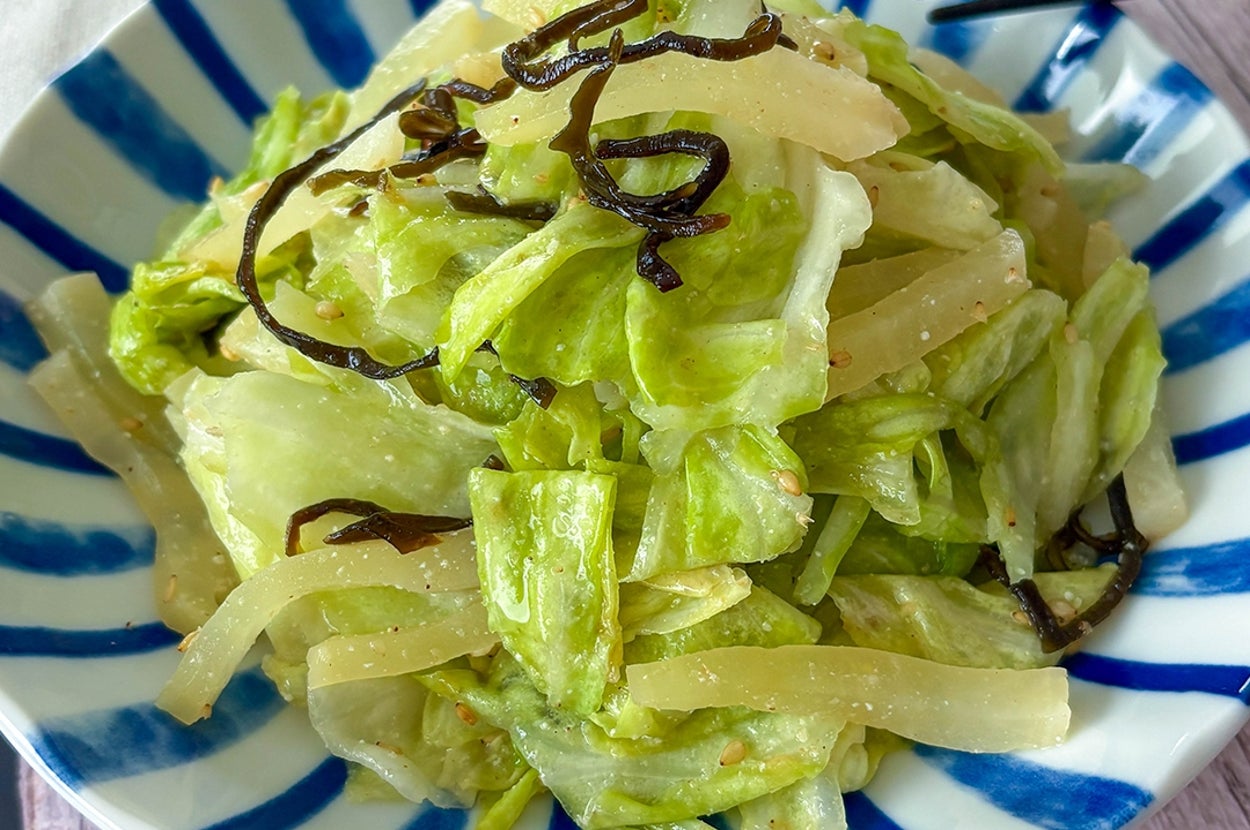 キャベツとたくあんのごま塩昆布和えが青いストライプ模様の皿に盛られている。
