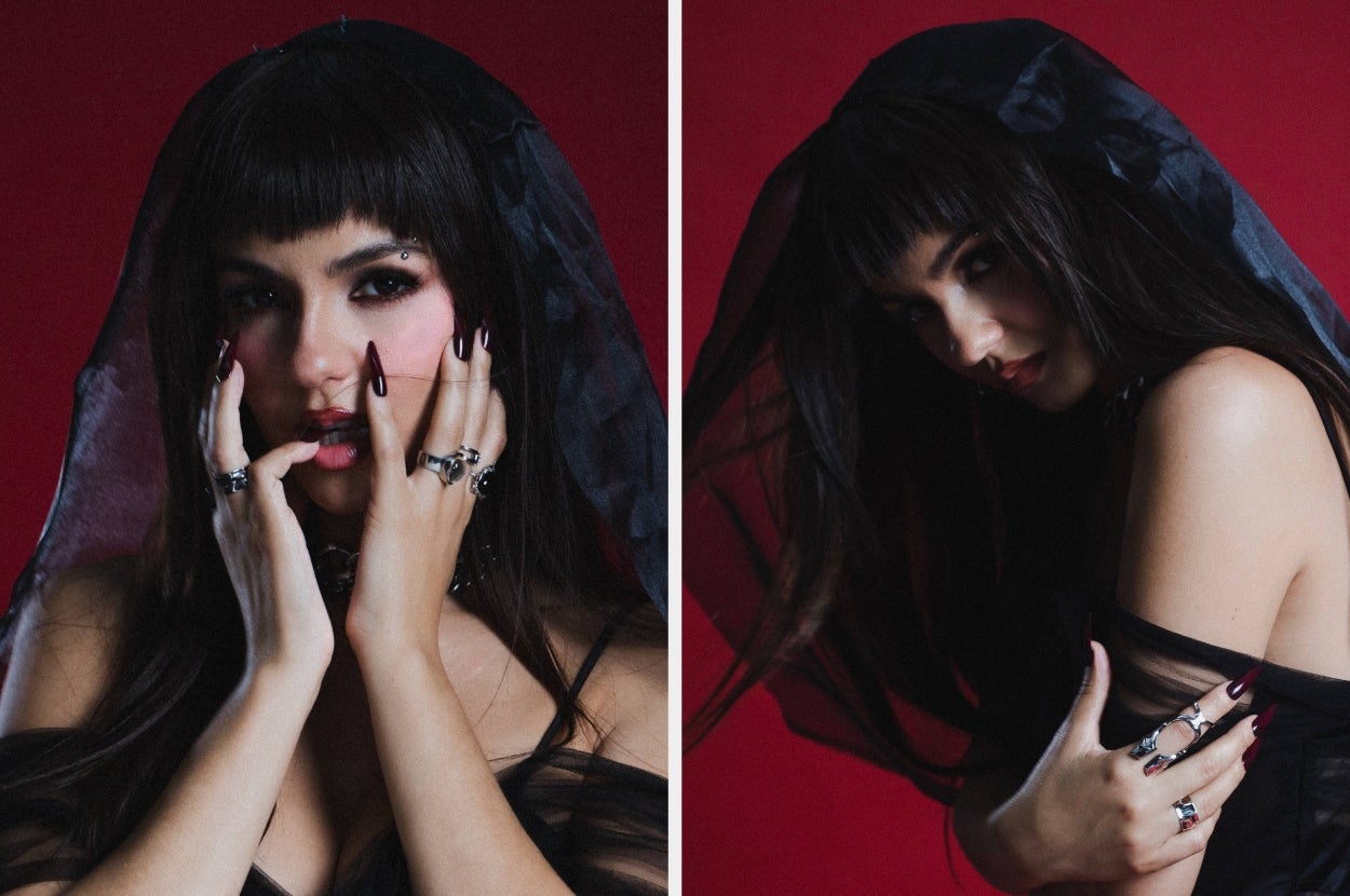 Person in sheer black veil and rings, posing with dramatic hand gestures against a dark background
