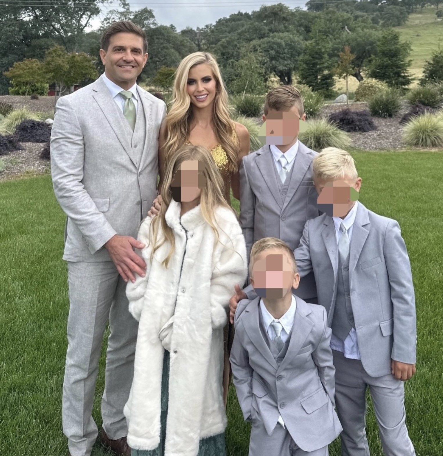 A radical of six radical outdoors, 2 adults successful ceremonial deterioration and 4 children successful suits and a dress. Faces are blurred for privacy
