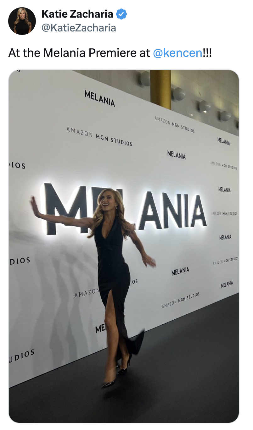 Woman successful a stylish achromatic gown with a thigh-high slit poses playfully astatine "Melania" premiere backdrop