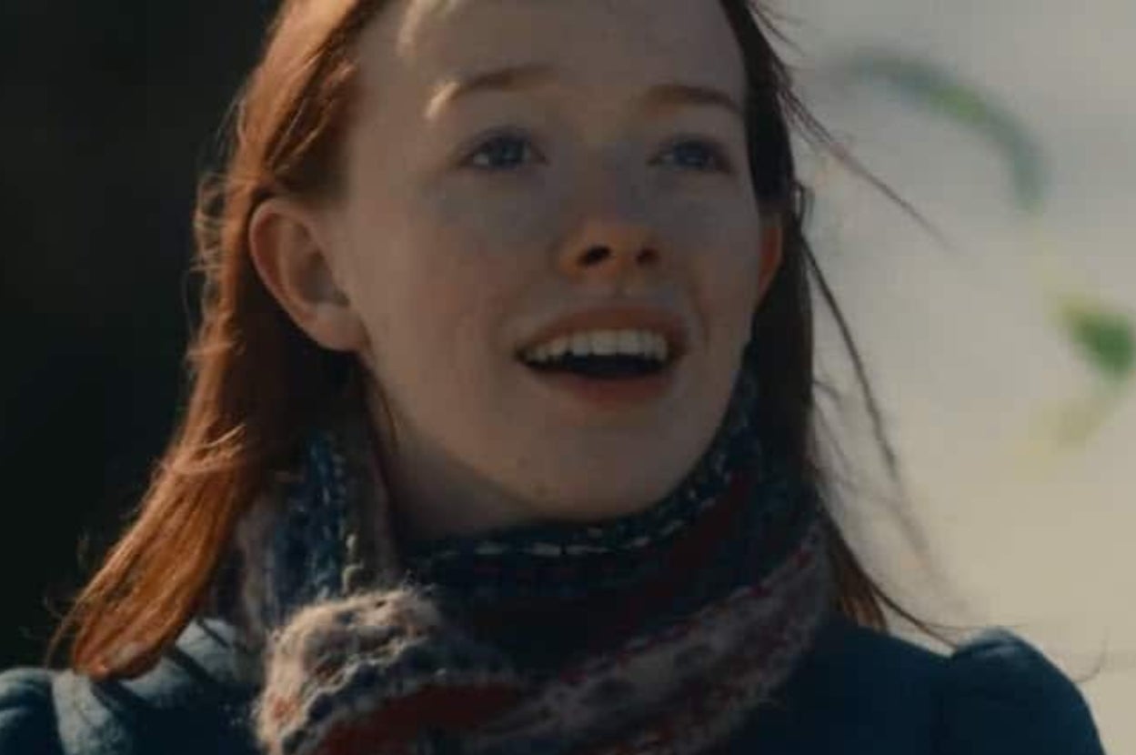 Person outdoors smiling brightly, wearing a patterned scarf