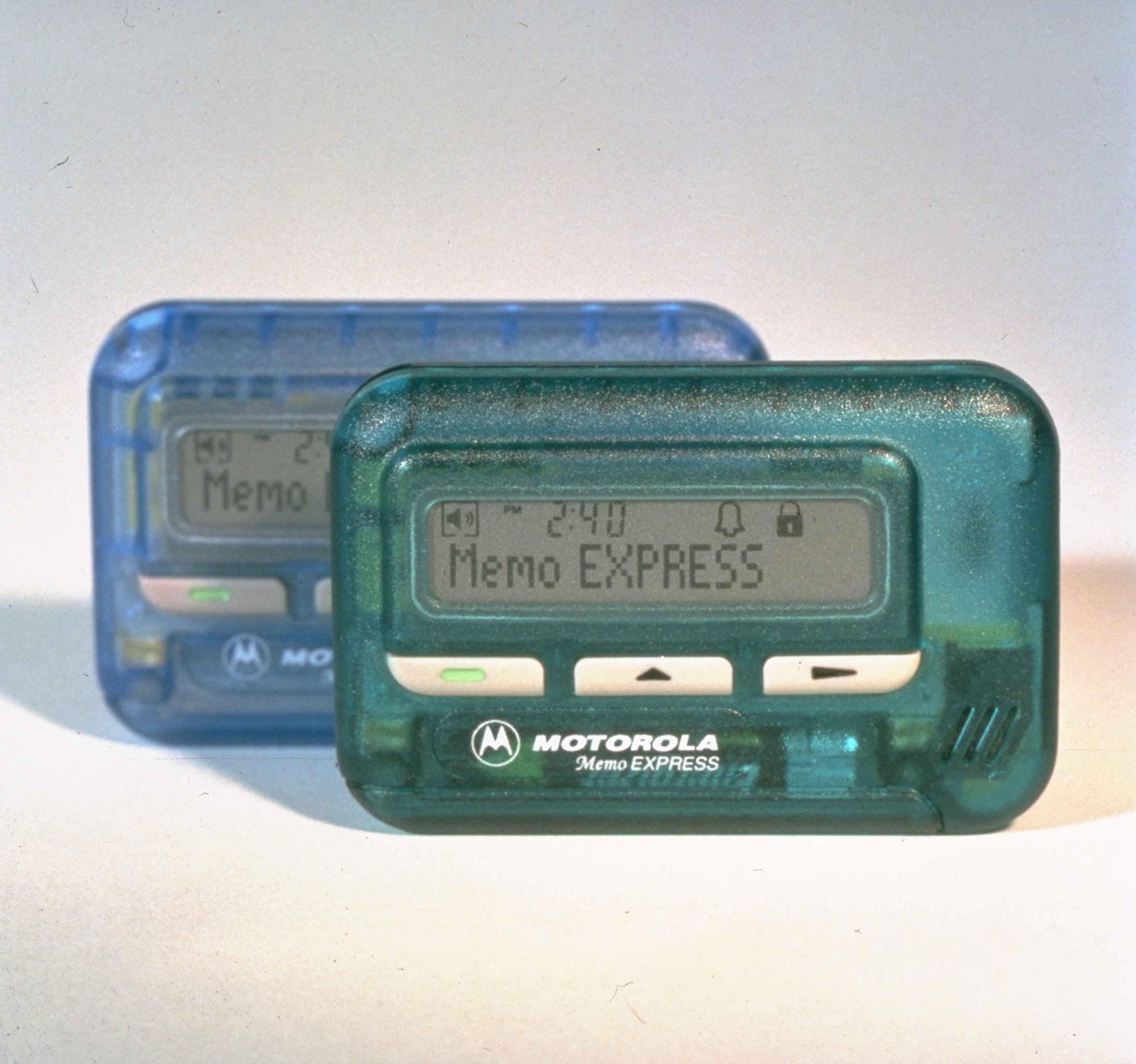 Two Motorola Memo Express pagers, one in front of the other, displaying "Memo" on their screens