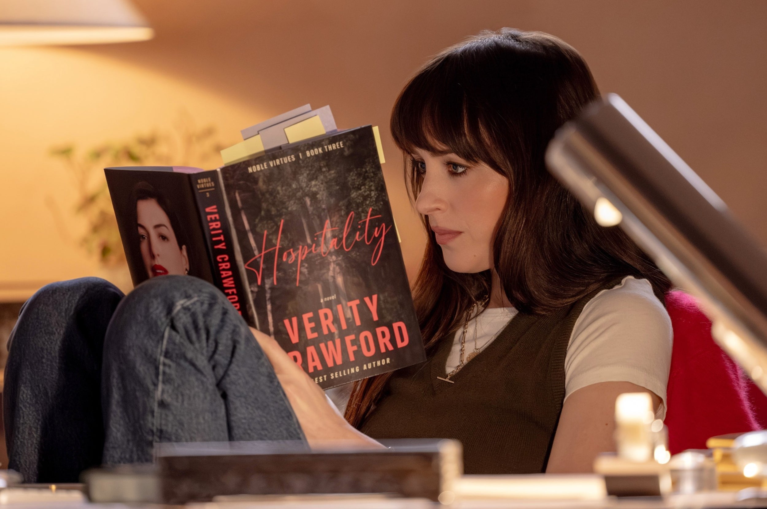 Dakota Johnson reading a book by Verity Crawford as Lowen in Verity