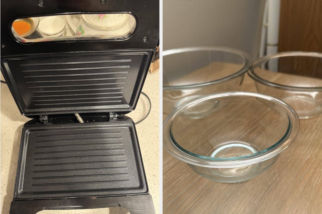 Panini press open next to three glass mixing bowls on a table