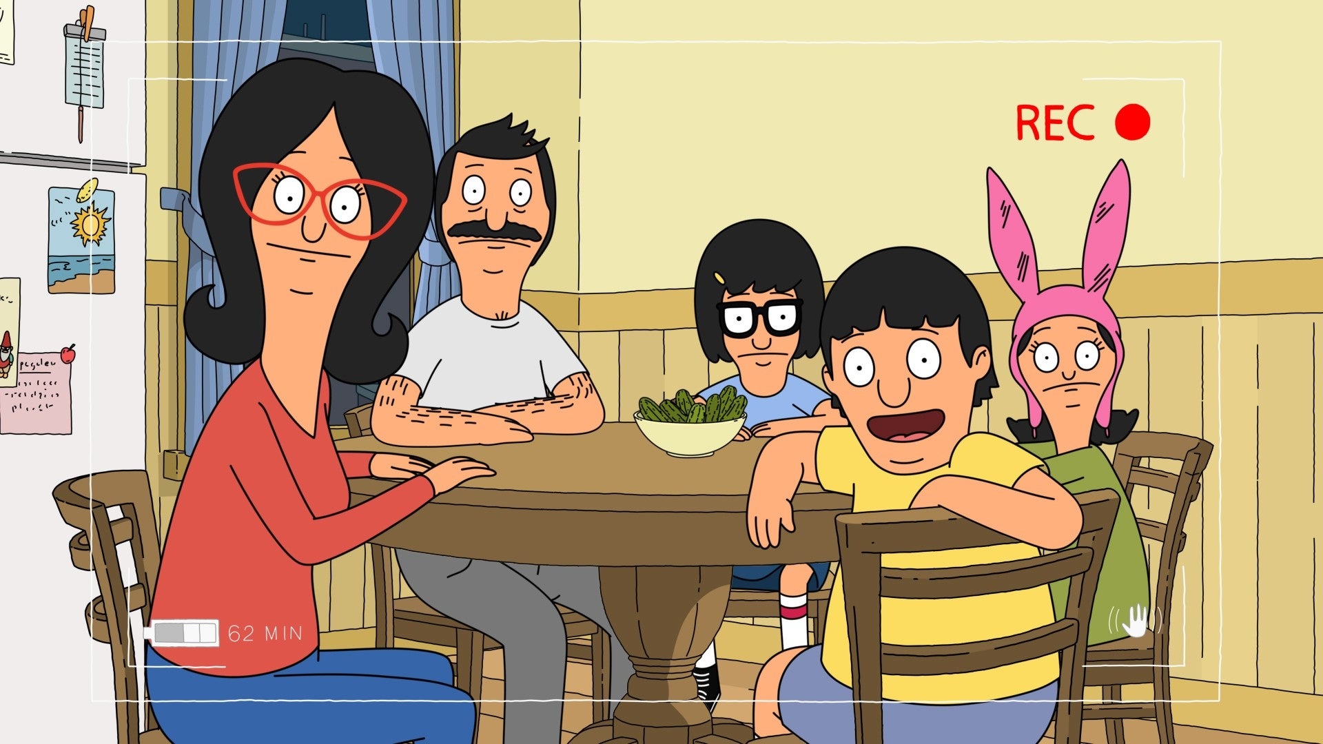 Animated family sitting around a kitchen table. One character wears glasses, another has a mustache, and one wears pink bunny ears