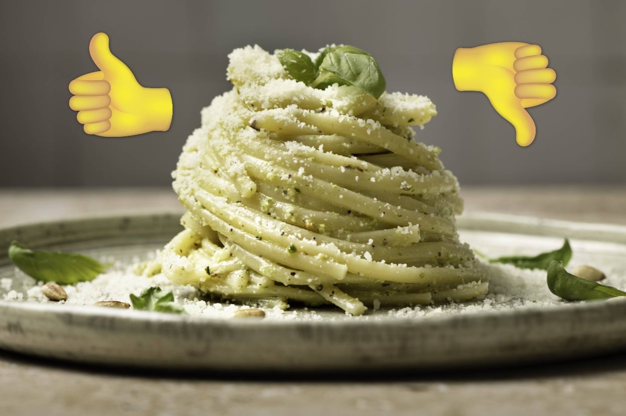 A plate of neatly stacked pasta with sauce and cheese, garnished with basil. Thumbs-up and thumbs-down emojis above, possibly indicating preference