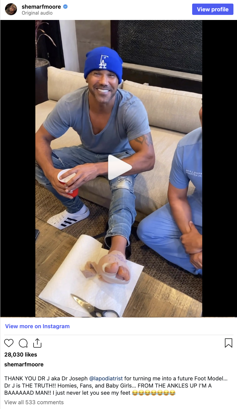 Two radical   sitting, smiling. Person connected  the near  has ft  bandaged and elevated. They deterioration  casual clothes, including a beanie and hoodie. Instagram post