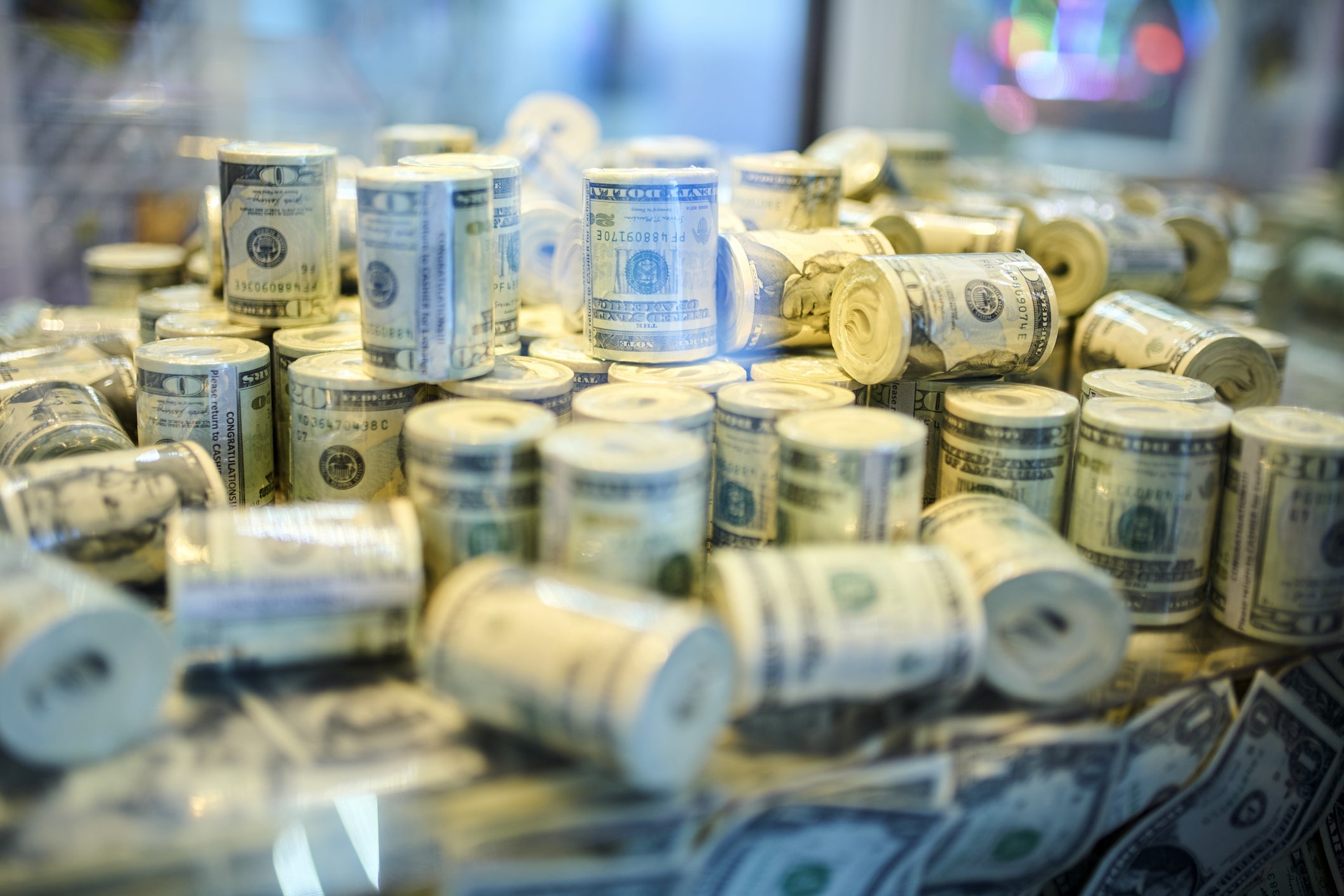 Stacks of rolled U.S. dollar bills are displayed, illustrating wealth or financial abundance
