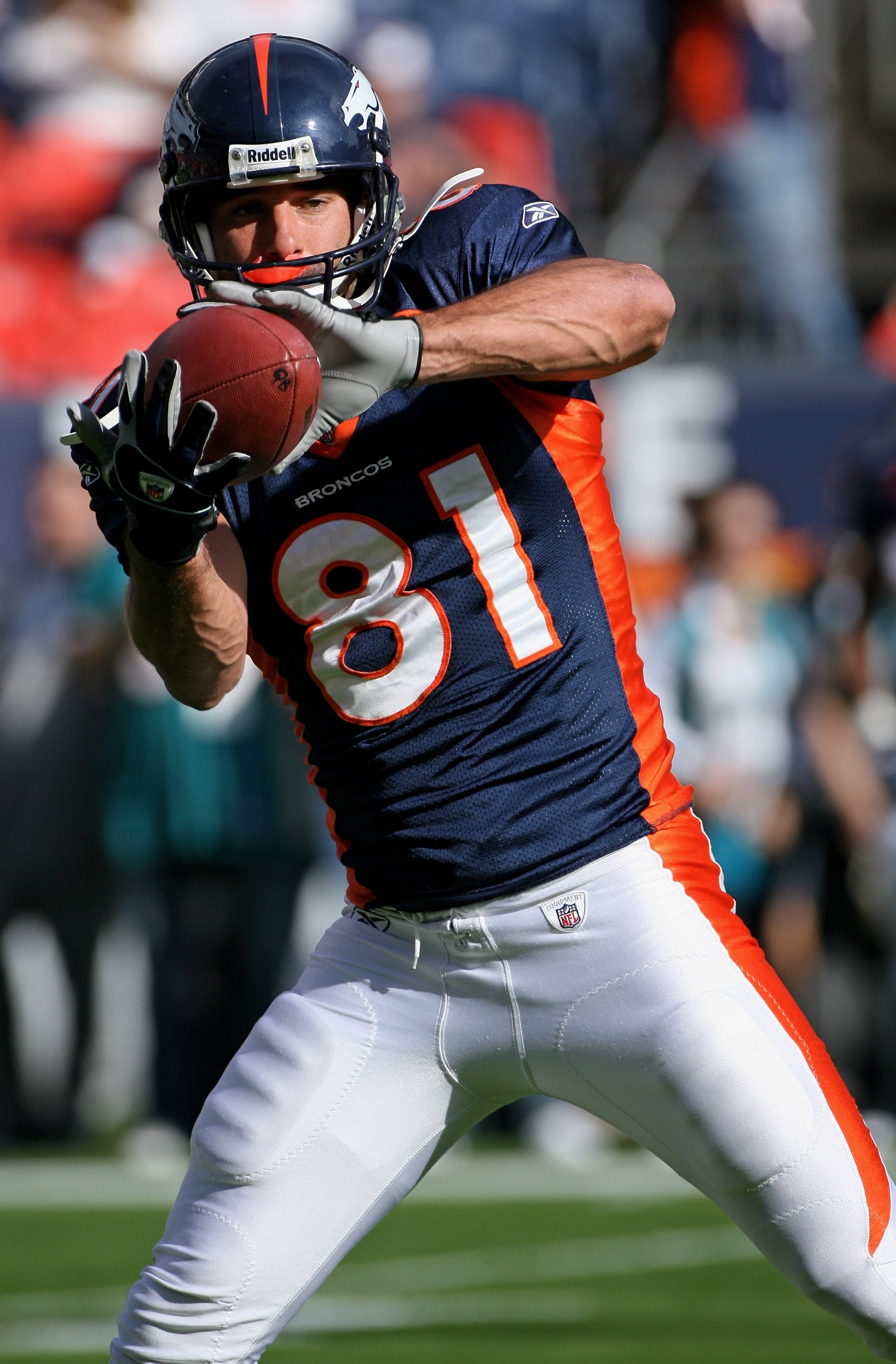 Football player in motion catching a ball during a game, wearing a jersey numbered 81