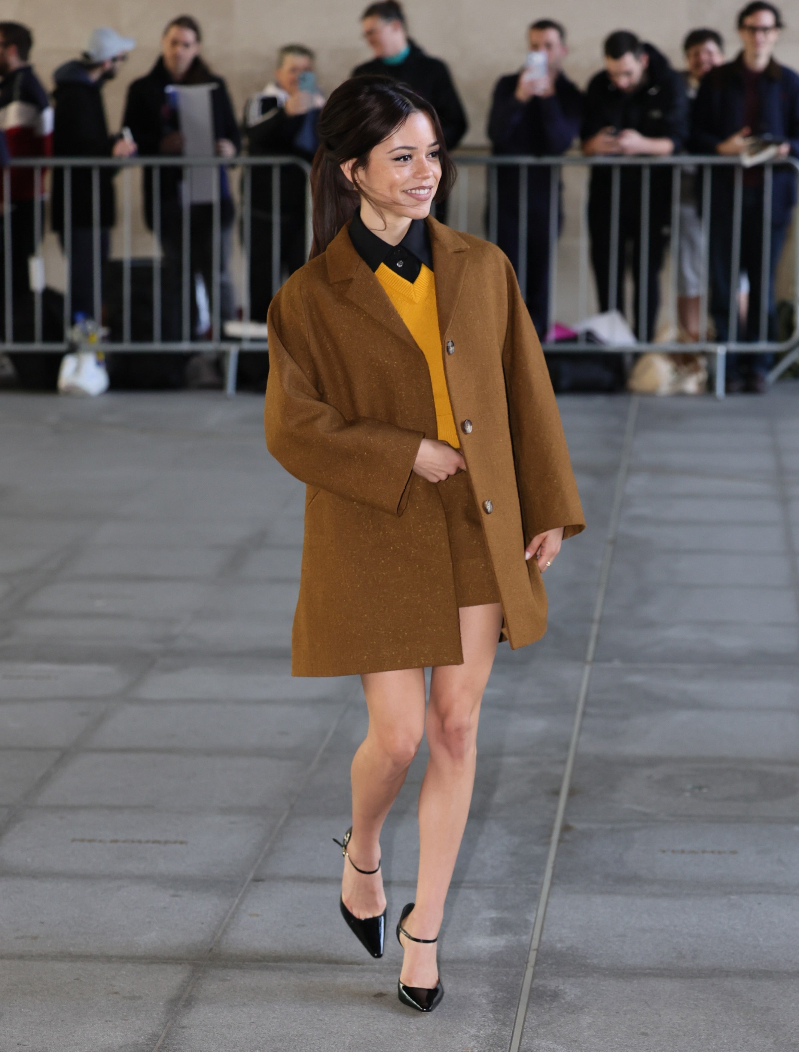 Jenna Ortega’s darker brows in London, October 2026 Jenna Ortega wearing darker, defined eyebrows with a camel coat and yellow knit in London in October 2026
