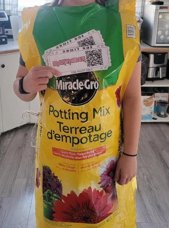 Person dressed successful a potting premix container costume holding a paper, presumably a prize, labeled "Won astir originative costume astatine school!"