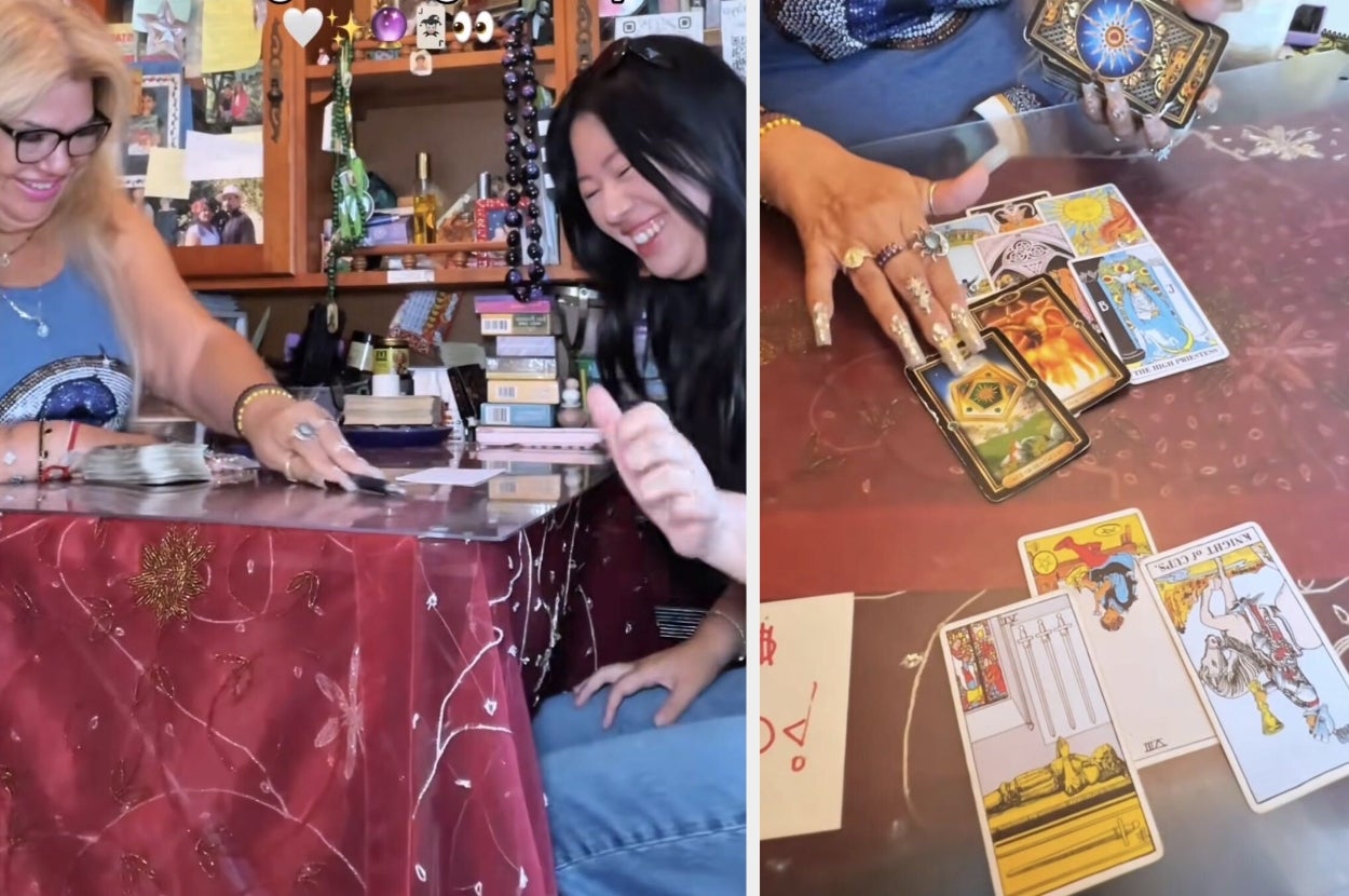 Two people sitting at a table, smiling, as they engage in a tarot card reading with several cards laid out in front of them