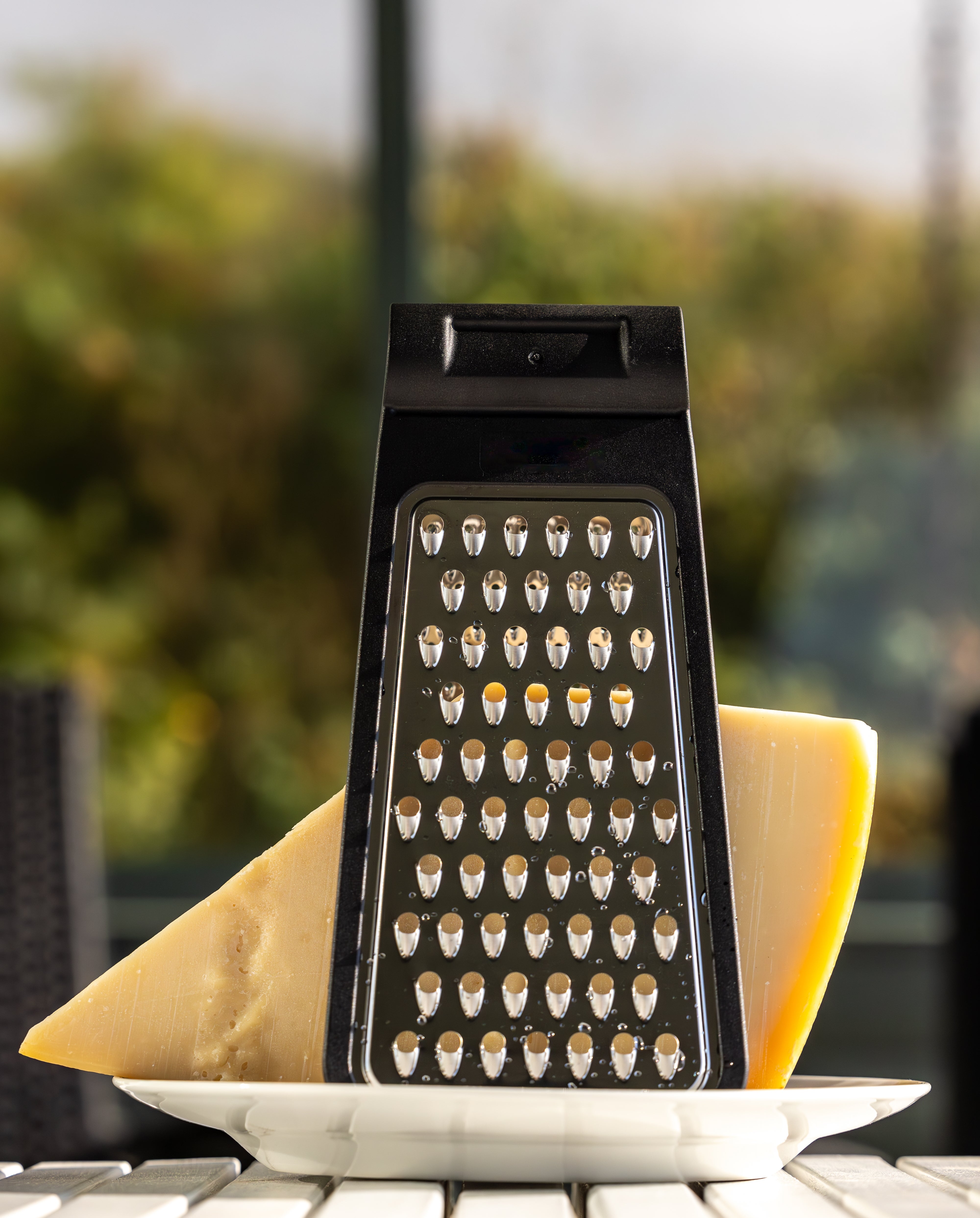 Cheese grater connected a sheet with ample food slices outside, acceptable against a blurred earthy background