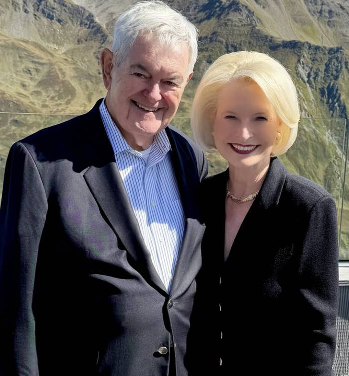 An older mates  successful  ceremonial  attire smiles for a photograph  against a mountainous backdrop