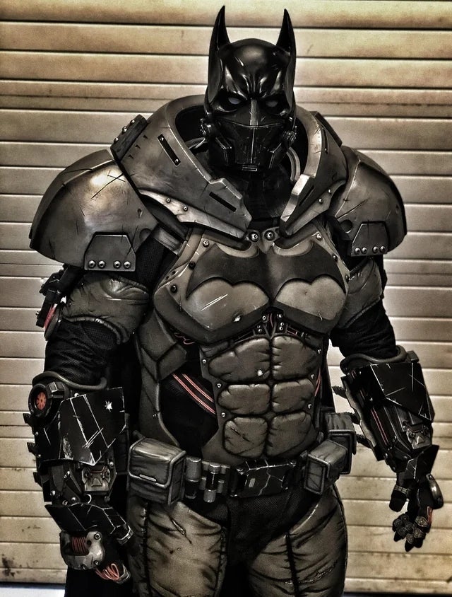 Person successful a futuristic, armored Batman-inspired costume with intricate details and a helmet featuring bat ears