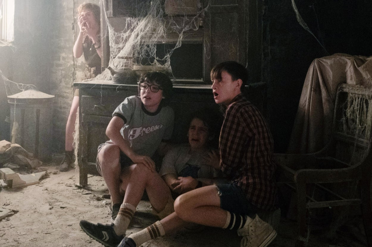 The Losers Club from It cowering in fear in a creepy, dusty, abandoned house