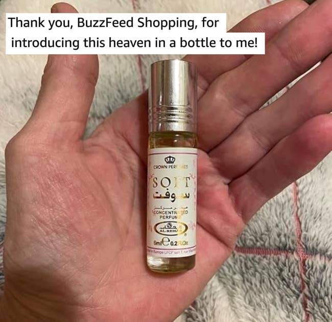 Hand holding a tiny vessel of perfume labeled