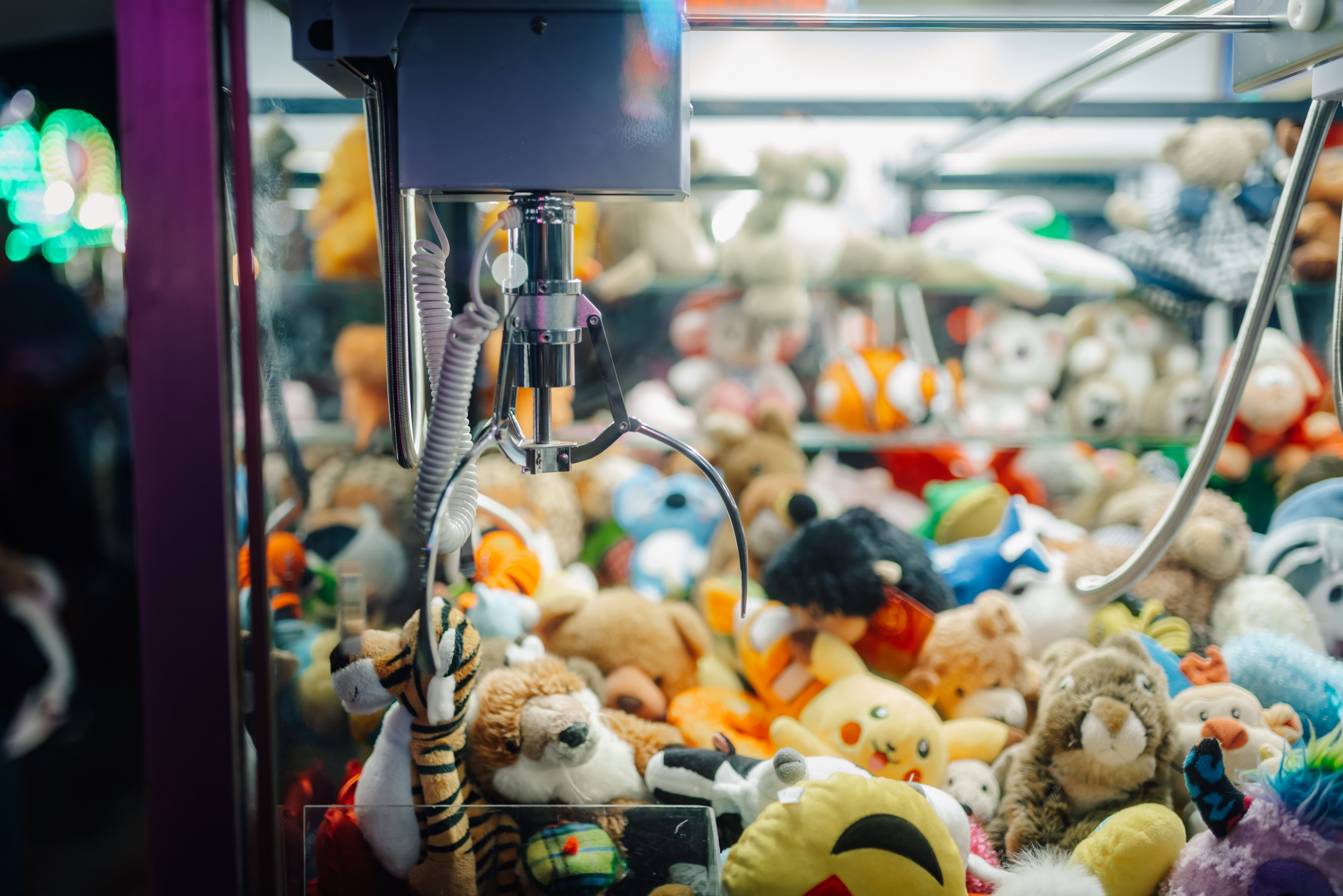Claw instrumentality filled with assorted plush toys, specified arsenic tigers, fish, and bears, waiting to beryllium picked by players