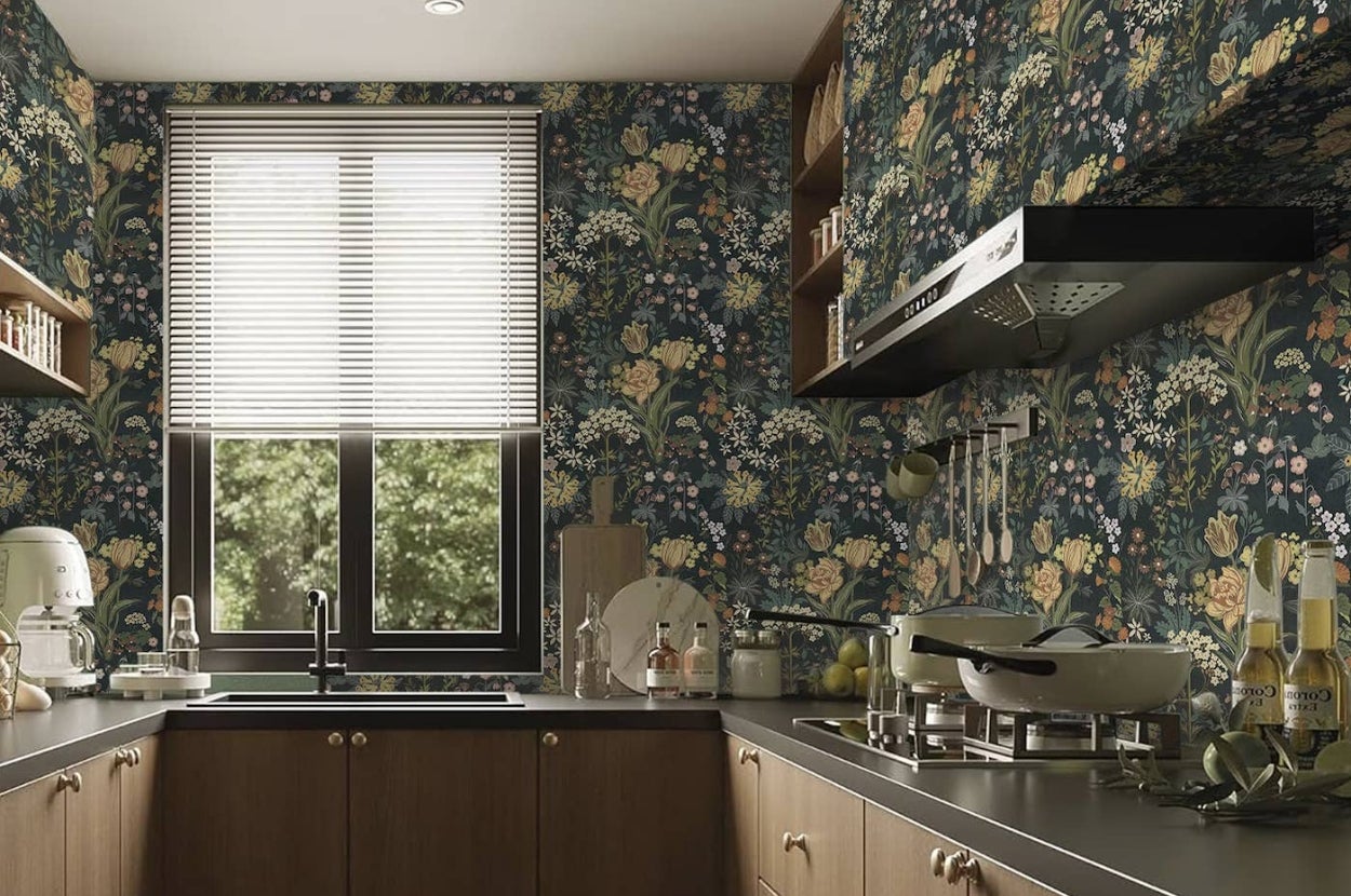 Kitchen with floral wallpaper, modern appliances, and wooden cabinets. A window with blinds overlooks the sink area