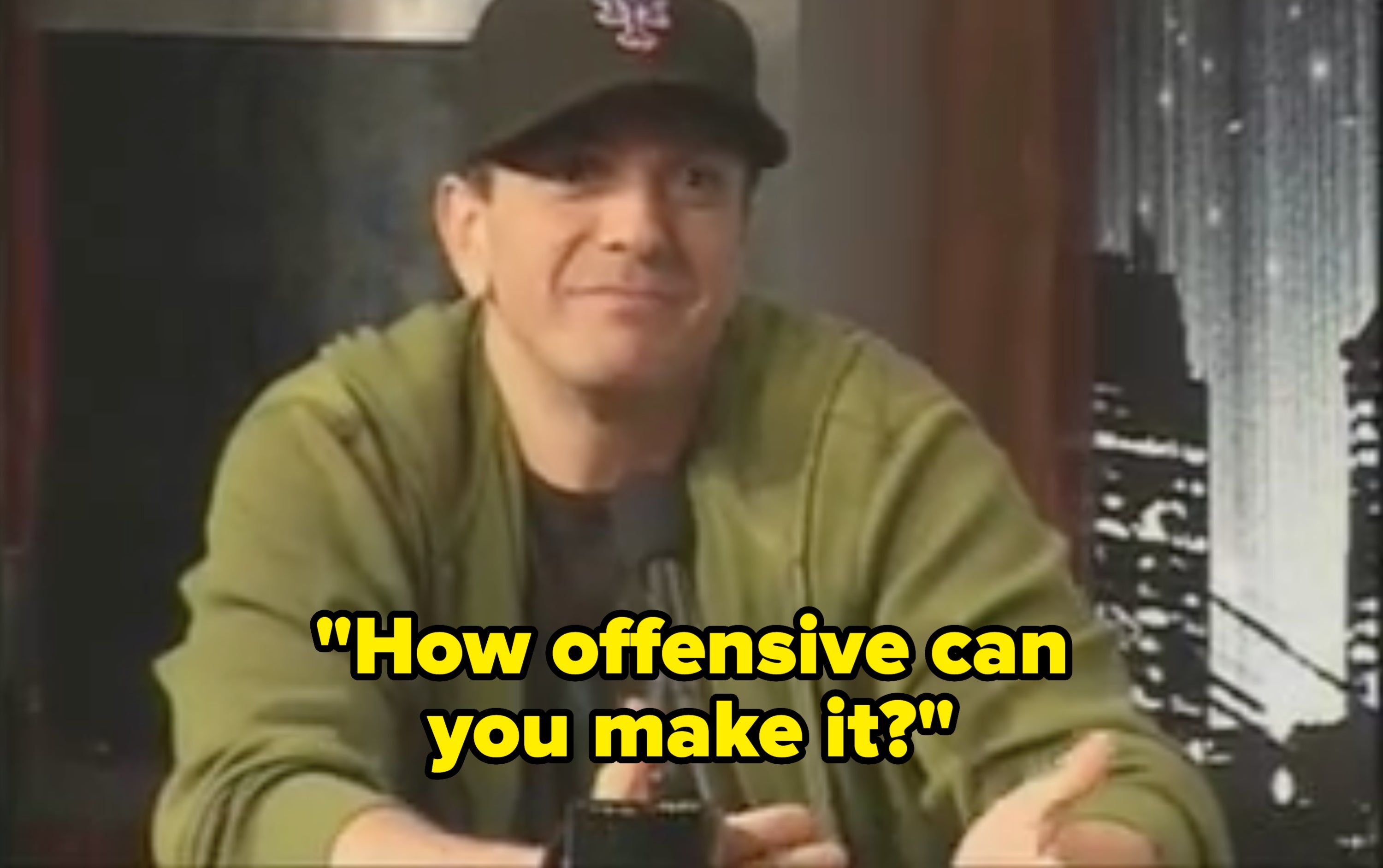Person wearing a shot headdress and hoodie speaking into a microphone connected a speech amusement set