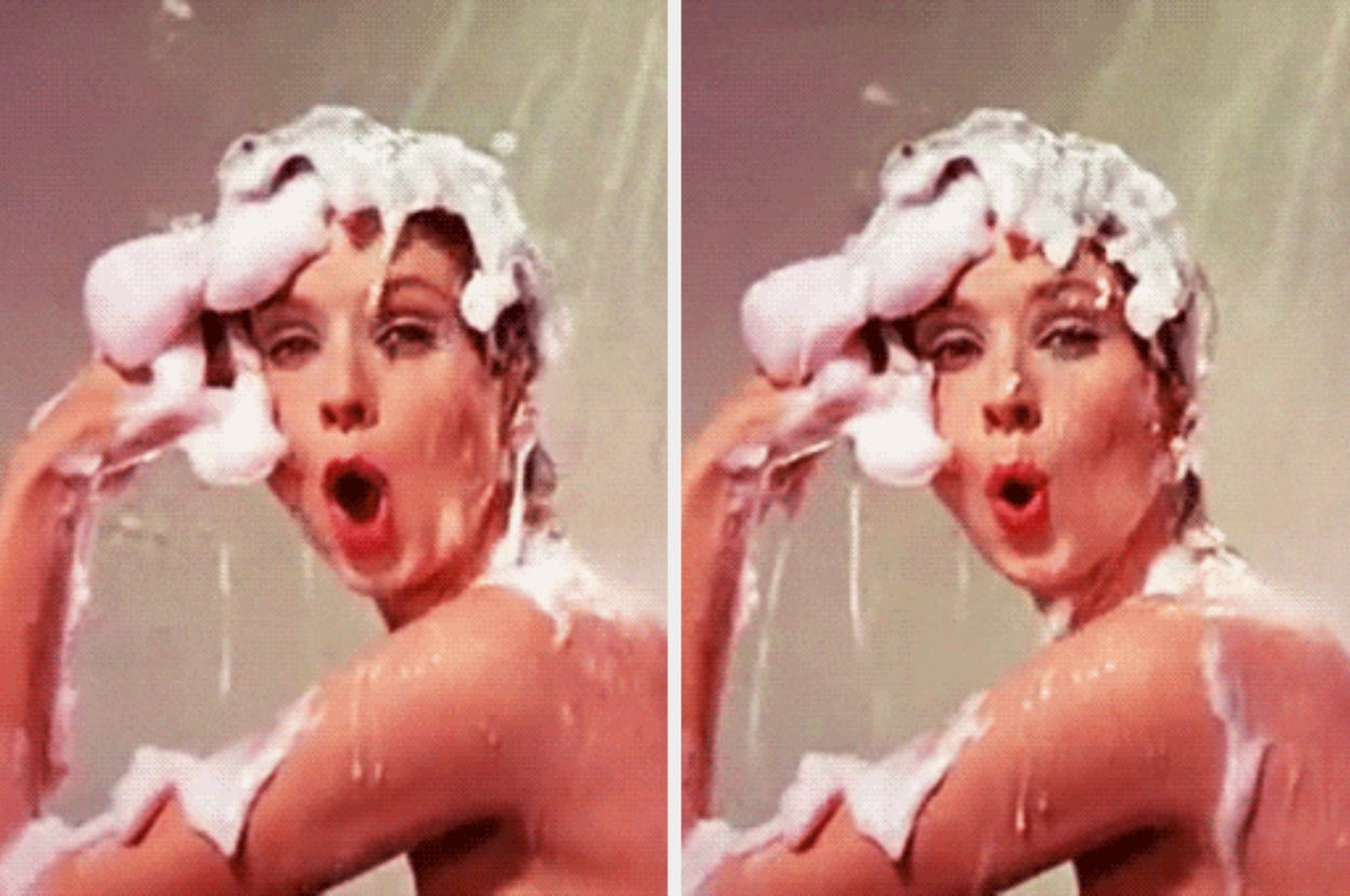 Person washing their hair with shampoo, forming a playful expression