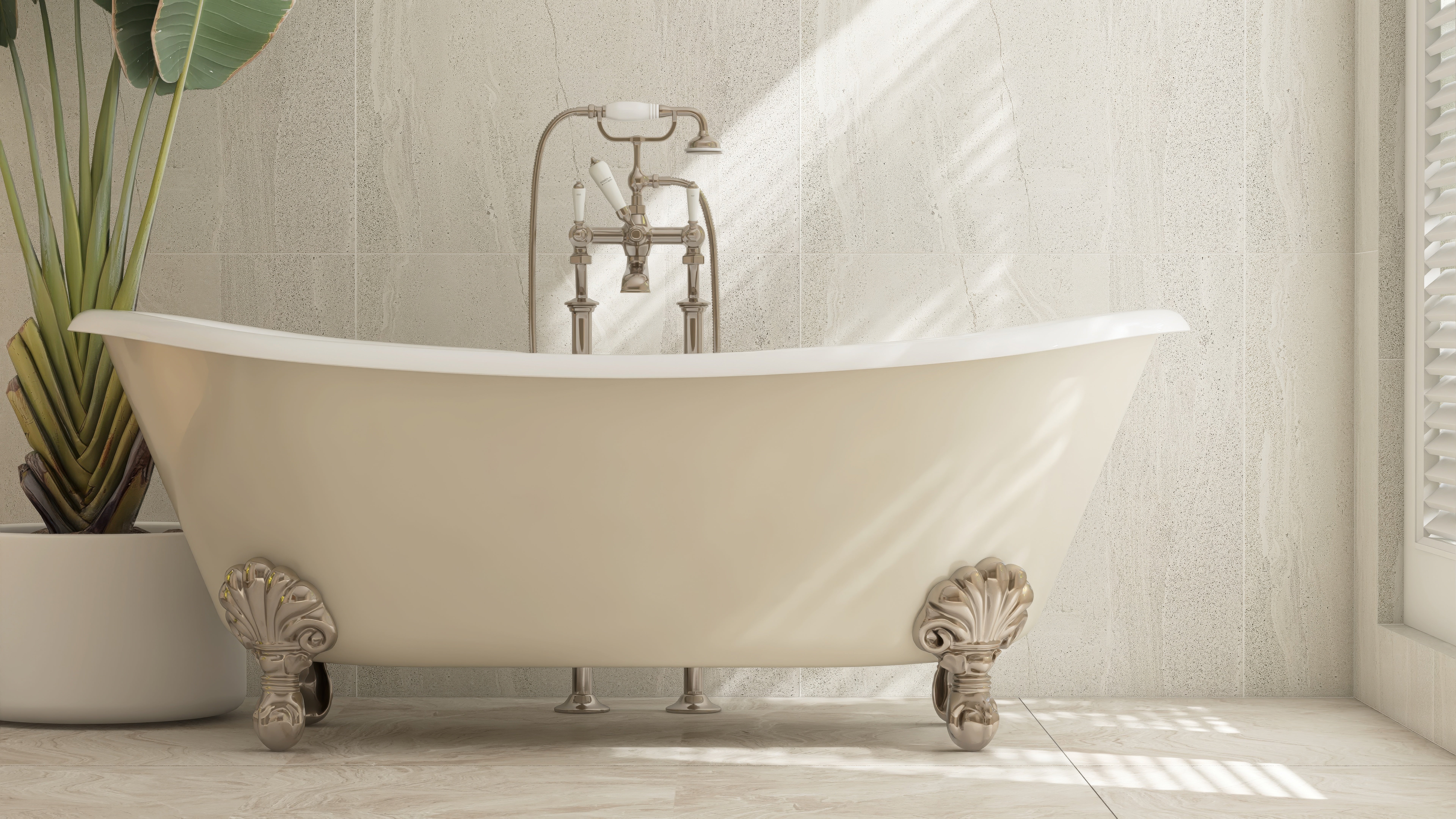 A vintage-style clawfoot bathtub with ornate metal legs sits against a tiled wall, next to a tall potted plant