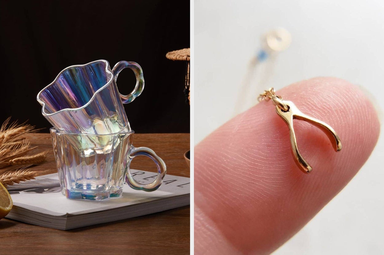 Glass mugs on geometric stands and a hand holding a gold wishbone charm necklace