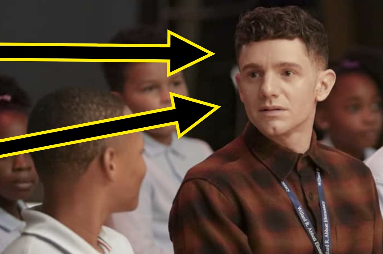 Person in a plaid shirt looking at a person sitting nearby. Large yellow arrows point toward them, suggesting attention or focus